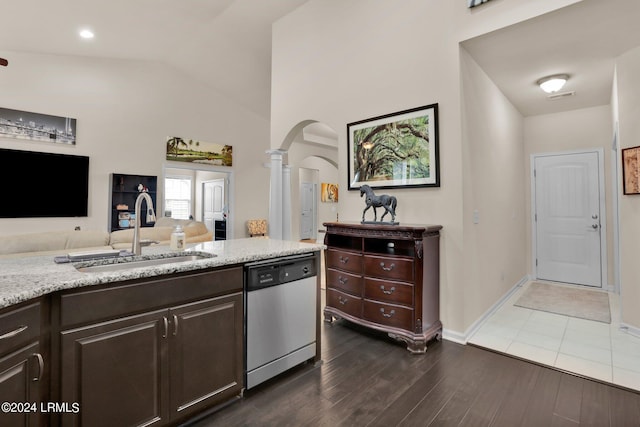 kitchen with lofted ceiling, sink, stainless steel dishwasher, dark wood-type flooring, and dark brown cabinets