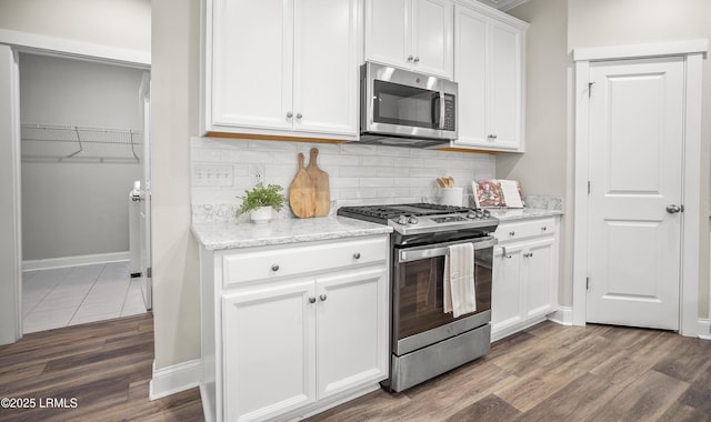 28 Laughing Gull Dr, Beaufort, SC 29907 - kitchen with stainless steel appliances, tasteful backsplash, white cabinetry, and dark wood-type flooring
