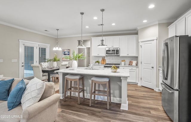 28 Laughing Gull Dr, Beaufort, SC 29907 - kitchen with stainless steel appliances, a sink, crown molding, tasteful backsplash, and white cabinetry