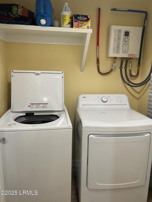 clothes washing area with washing machine and dryer and tankless water heater