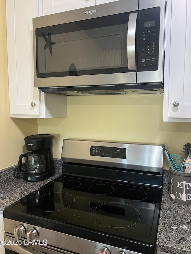 interior details with dark stone countertops, white cabinets, and appliances with stainless steel finishes