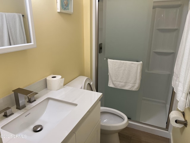 bathroom with vanity, wood-type flooring, a shower with shower door, and toilet