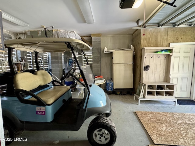 garage featuring freestanding refrigerator and a garage door opener