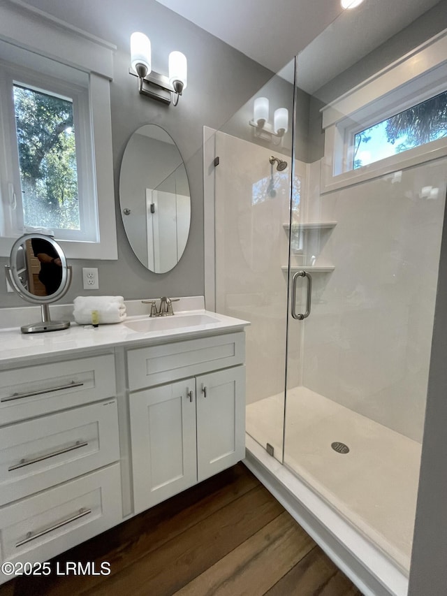 full bath featuring a stall shower, wood finished floors, and vanity