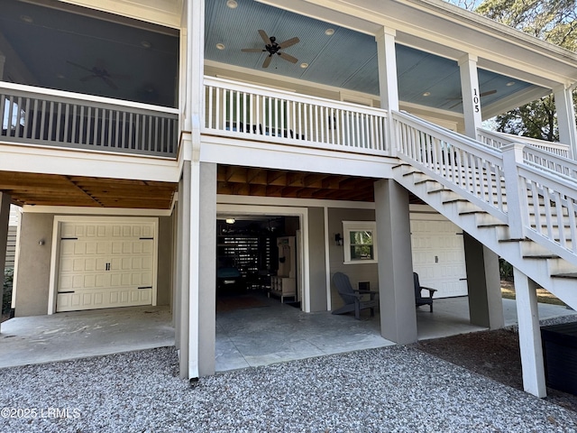 view of exterior entry with gravel driveway, an attached garage, a ceiling fan, and a patio