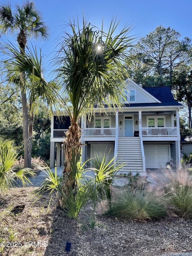 raised beach house featuring a garage and stairway