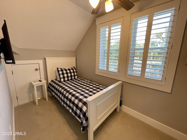 bedroom featuring light colored carpet, lofted ceiling, multiple windows, and baseboards