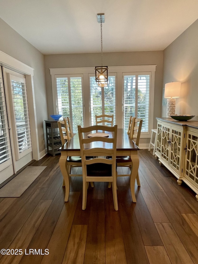 dining space with plenty of natural light, baseboards, and dark wood finished floors