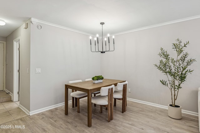 dining area with a notable chandelier, crown molding, and light hardwood / wood-style flooring