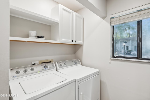 clothes washing area with cabinets and independent washer and dryer