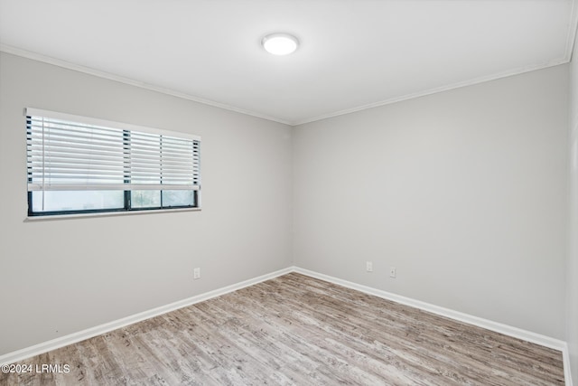 spare room featuring crown molding and light wood-type flooring