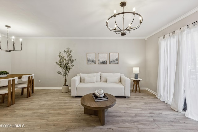 living room featuring ornamental molding, a chandelier, and light hardwood / wood-style floors