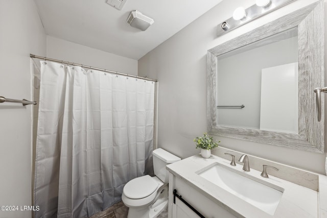 bathroom featuring vanity, walk in shower, and toilet