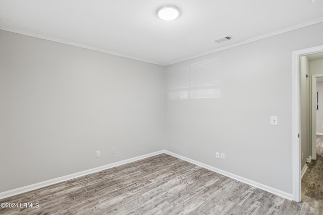 spare room with ornamental molding and light hardwood / wood-style floors