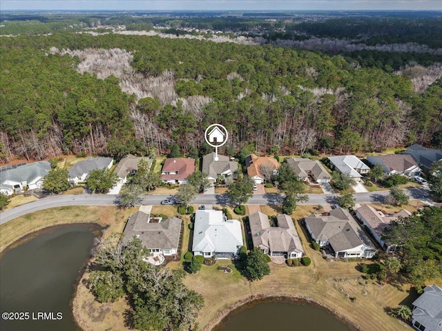 drone / aerial view with a water view and a forest view