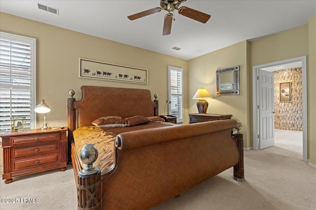 bedroom with visible vents, a ceiling fan, and light colored carpet