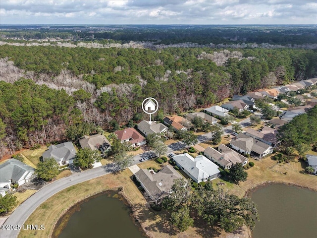 aerial view featuring a forest view, a water view, and a residential view