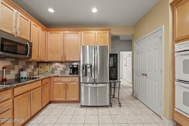 kitchen with light tile patterned floors, recessed lighting, backsplash, appliances with stainless steel finishes, and stone countertops