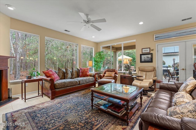 living area featuring a wealth of natural light, french doors, light tile patterned flooring, and visible vents