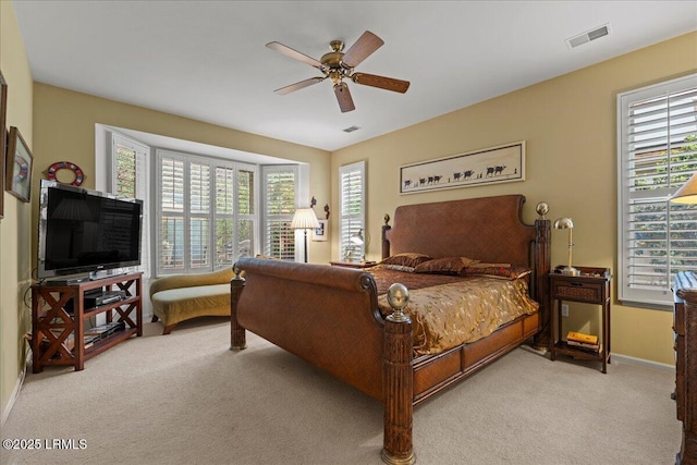 bedroom featuring a ceiling fan, light carpet, visible vents, and baseboards