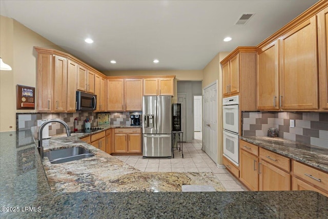 kitchen with light tile patterned floors, white double oven, a sink, visible vents, and stainless steel refrigerator with ice dispenser