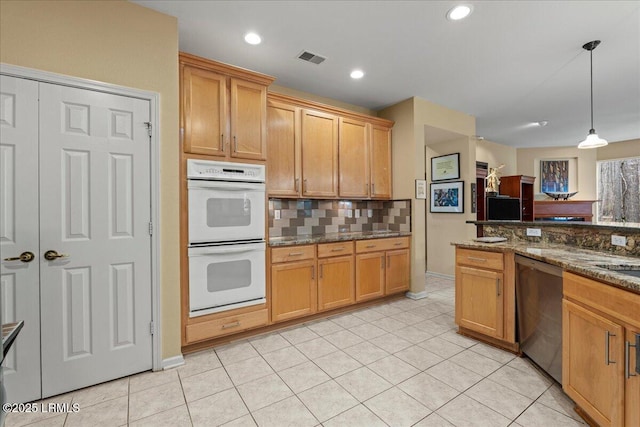 kitchen with double oven, visible vents, dishwasher, dark stone countertops, and pendant lighting