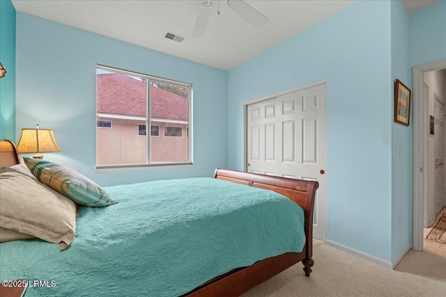 bedroom with ceiling fan, light colored carpet, visible vents, baseboards, and a closet