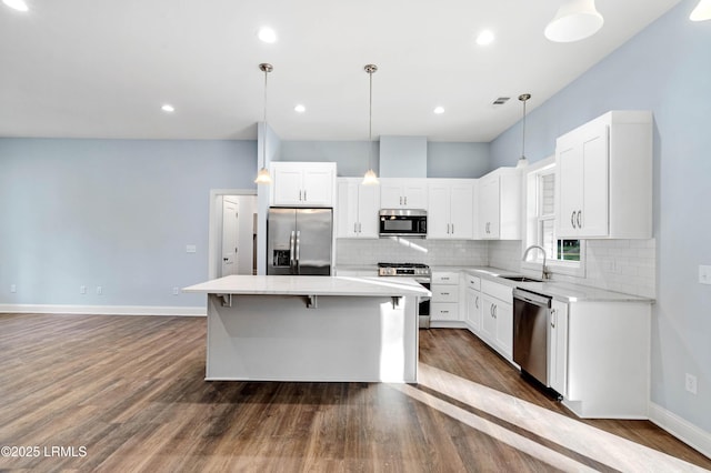95 Salkehatchie Rd, Yemassee, SC 29945 - kitchen featuring appliances with stainless steel finishes, a center island, decorative backsplash, a sink, and dark wood-style floors