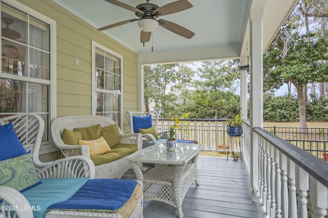 wooden terrace featuring a ceiling fan and an outdoor living space