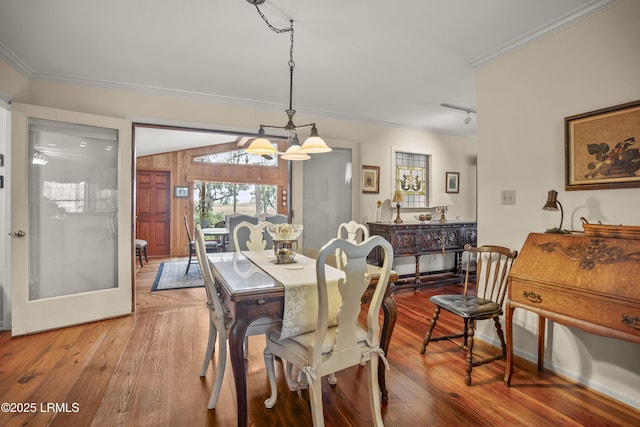 dining area with a chandelier, hardwood / wood-style flooring, and ornamental molding