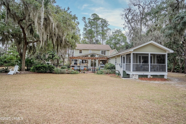 back of property with a lawn and a sunroom