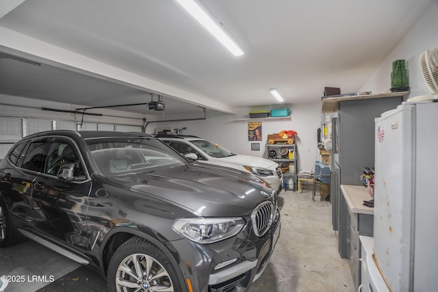 garage with a garage door opener and white fridge