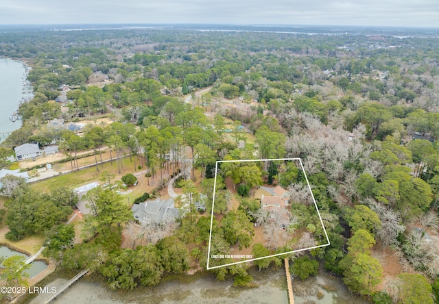 birds eye view of property featuring a forest view and a water view