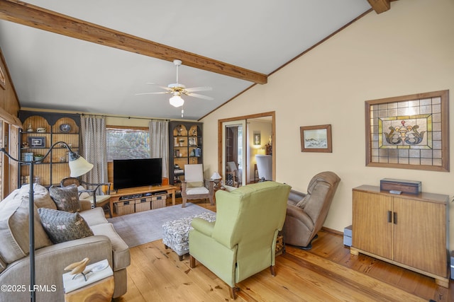 living area featuring lofted ceiling with beams, light wood-style floors, and ceiling fan