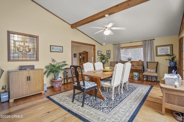 dining area with beamed ceiling, high vaulted ceiling, ceiling fan, and light wood finished floors