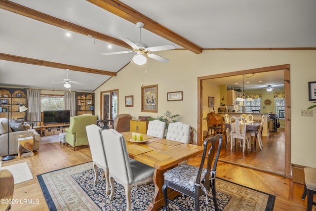 dining area with light wood-style flooring and lofted ceiling with beams