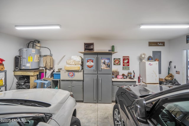 garage featuring electric water heater and freestanding refrigerator