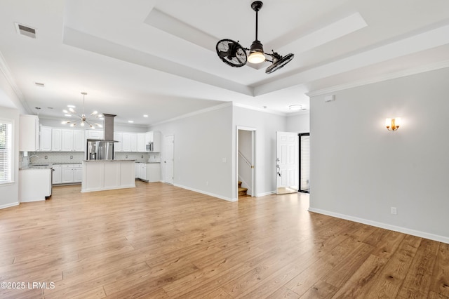 5 Susan Ct, Beaufort, SC 29907 - unfurnished living room with a chandelier, a raised ceiling, light wood finished floors, stairs, and recessed lighting