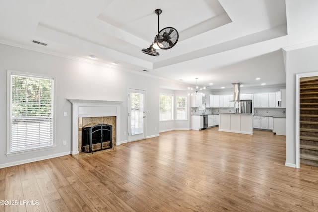 5 Susan Ct, Beaufort, SC 29907 - unfurnished living room with a raised ceiling, a chandelier, a tiled fireplace, stairs, and recessed lighting