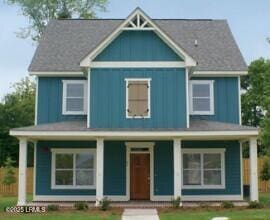 view of front of property with a porch, a front yard, and board and batten siding