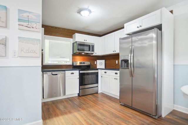 kitchen featuring backsplash, dark hardwood / wood-style floors, white cabinets, and appliances with stainless steel finishes