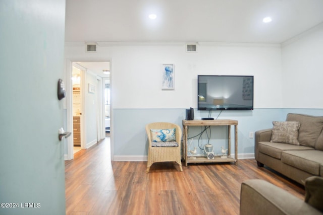 living room with hardwood / wood-style flooring and crown molding