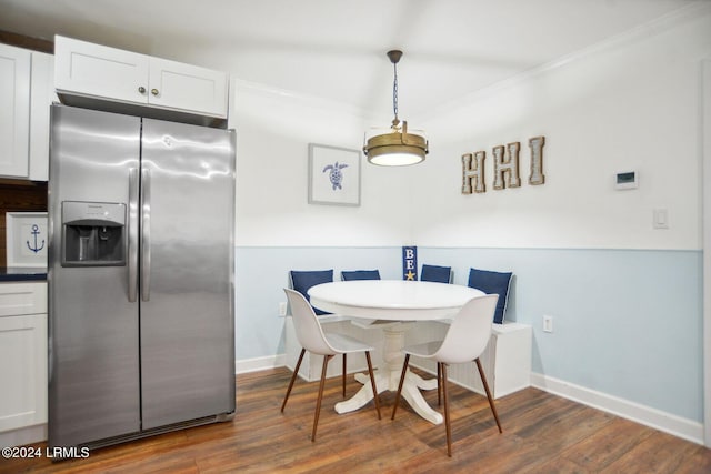 dining room featuring ornamental molding and dark hardwood / wood-style flooring