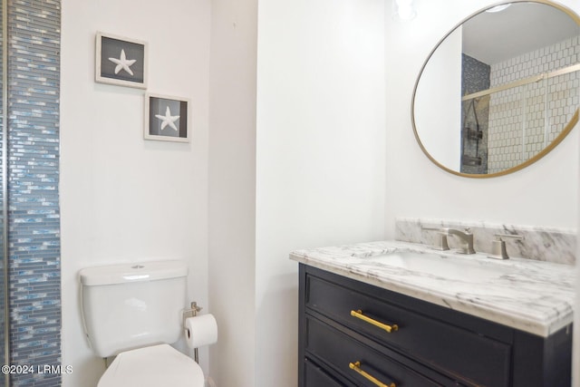 bathroom featuring vanity, a shower, and toilet