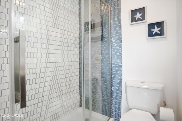 bathroom featuring walk in shower and toilet