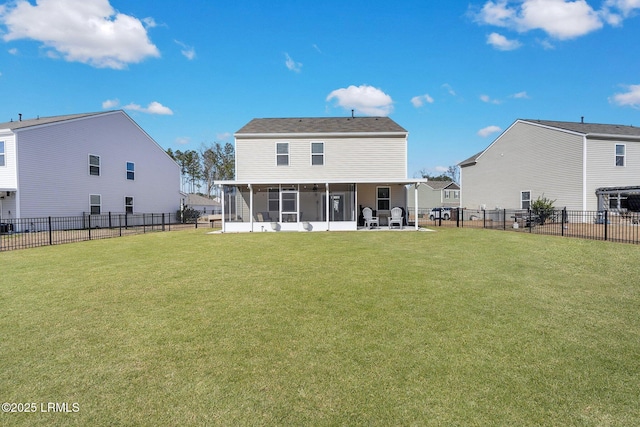 rear view of house with a sunroom and a lawn