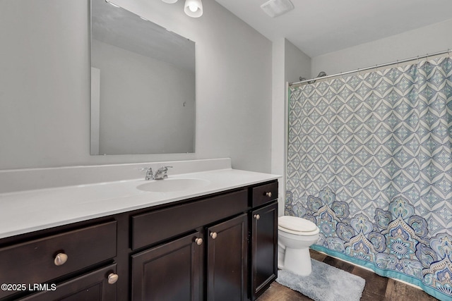 bathroom with hardwood / wood-style flooring, vanity, and toilet