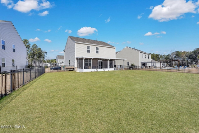 rear view of house with a sunroom and a lawn