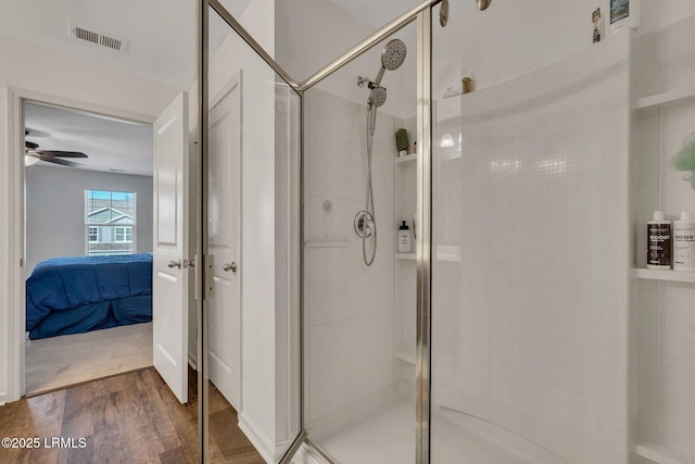 bathroom featuring walk in shower, ceiling fan, and hardwood / wood-style floors