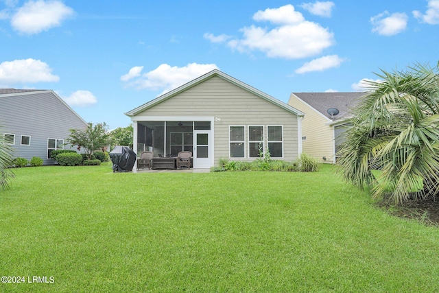 back of house featuring a sunroom and a lawn